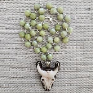 GREEN JADE NECKLACE WITH BULL SKULL PENDANT.